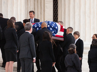 The flag-draped casket of Associate Justice Sandra Day O’Connor, the first woman to serve on the Supreme Court, passes between two lines of...