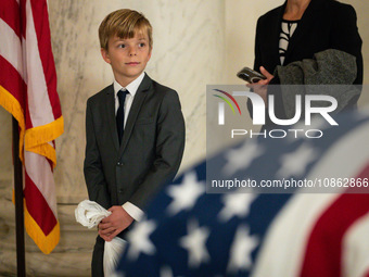 A young boy looks at the flag-draped  asker of Retired Associate Justice Sandra Day O’Connor, the first woman to serve on the Supreme Court,...