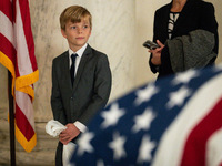 A young boy looks at the flag-draped  asker of Retired Associate Justice Sandra Day O’Connor, the first woman to serve on the Supreme Court,...