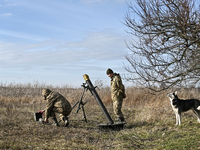 Servicemen from an artillery unit of the 128th Mountain Assault Brigade of the Ukrainian Ground Forces are standing by a 120mm mortar during...