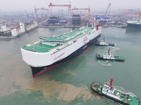 The large car carrier BYD Explorer 1 is being assisted by a tugboat at CIMC Raffles' Shandong Longkou construction base in Yantai, China, on...