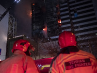 Firefighters are at the site of the fire at the Gandhi hotel hospital in northern Tehran, Iran, on January 25, 2024. They are safely evacuat...