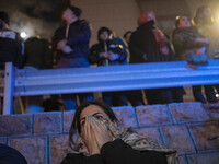 An Iranian woman is reacting while standing at the site of the fire at the Gandhi hotel hospital in northern Tehran, Iran, on January 25, 20...