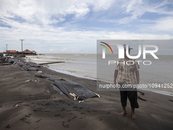 Carmat, 83, is posing for a photo near his house, which was destroyed by high waves in Cemarajaya Village, Karawang Regency, West Java Provi...