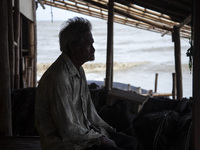 Carmat, 83, is staring out to sea near the remains of his house, which was destroyed by high waves in Cemarajaya Village, Karawang Regency,...