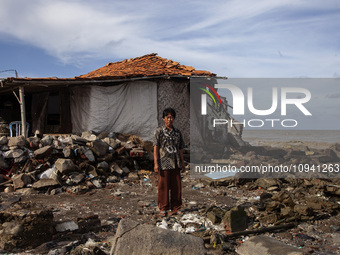 Jusiang Juwandi (56) is posing for a photo next to his house, which has been destroyed by high waves, in Cemarajaya Village, Karawang Regenc...