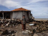 Jusiang Juwandi (56) is posing for a photo next to his house, which has been destroyed by high waves, in Cemarajaya Village, Karawang Regenc...
