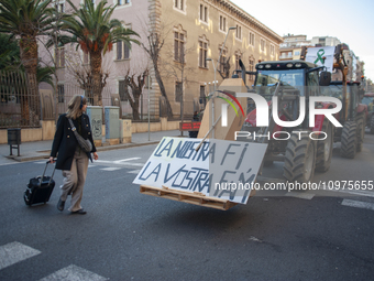 A tourist is reading the banner ''Our end is your hunger'' in Barcelona, Spain, on February 7, 2024. In light of the protests occurring acro...