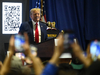 Former U.S. President Donald Trump is speaking on stage to promote self-branded golden sneakers during an appearance at SneakerCon at the Pe...