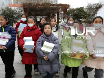 Students are receiving new textbooks at Yuanqian Primary School in Lianyungang, China, on February 20, 2024. (