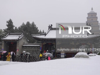 Tourists are braving the snow to queue up to enter the Dayan Pagoda at the Grand Tang Dynasty Everbright City scenic spot in Xi'an, China, o...