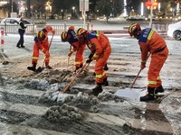 Fire and rescue workers are clearing snow from a road in Taizhou, Jiangsu Province, China, on February 23, 2024. (
