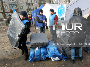 Volunteers are helping locals near a block of flats in Dnipro, Ukraine, on February 23, 2024, that was hit by a Russian Shahed drone during...