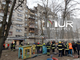 Rescuers are standing near a block of flats in Dnipro, Ukraine, on February 23, 2024, that was hit by a Russian Shahed drone during an overn...