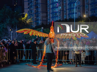 Tourists are watching a remote-controlled performance of the Double Phoenix Flying Performance, which is equipped with a power unit, being r...