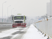 A sanitation worker is driving a vehicle to clear snow and ice on the road in Huai'an, China, on February 24, 2024. (