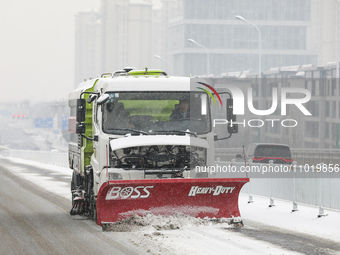 A sanitation worker is driving a vehicle to clear snow and ice on the road in Huai'an, China, on February 24, 2024. (