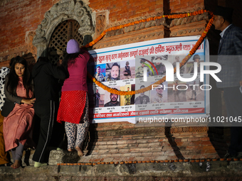 Families of deceased Nepali citizens are offering garlands over a banner containing photos of those killed in Russia during a vigil ceremony...