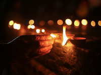 A family member of a deceased Nepali citizen, who was fighting for Russia, is holding a lamp during a vigil ceremony in Kathmandu, Nepal, on...