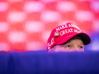 A Trump supporter is visible behind a divider as the My Pillow founder, Mike Lindell, speaks about rigged voting machines at
 the annual Con...