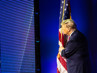 Donald Trump, ex-President and current presidential candidate, kisses and American flag before speaking at the annual Conservative Political...