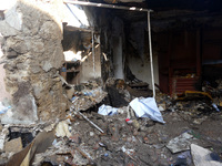 Furniture and personal belongings are lying in the remains of a house that is catching fire due to falling Russian drone debris after a Russ...