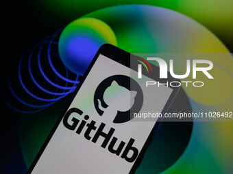 The GitHub logo is being displayed on a smartphone with the GitHub web home screen visible in the background in this photo illustration, in...
