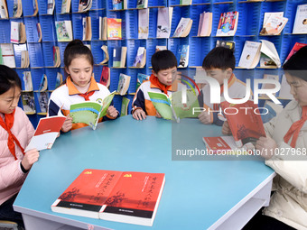 Primary school students are reading red books in Zaozhuang, East China's Shandong province, on February 26, 2024. (