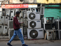 A person is passing by second-hand air conditioner machines inside a second-hand electronics market in Kolkata, India, on February 26, 2024....