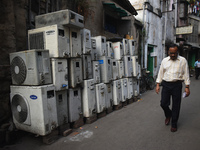 A person is passing by second-hand air conditioner machines inside a second-hand electronics market in Kolkata, India, on February 26, 2024....