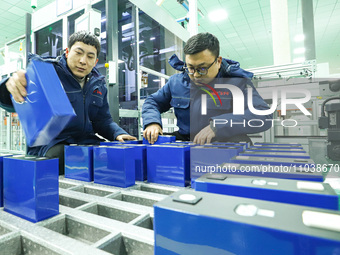 Workers are loading energy storage modules onto the production line at an automated facility for manufacturing energy storage equipment in Z...