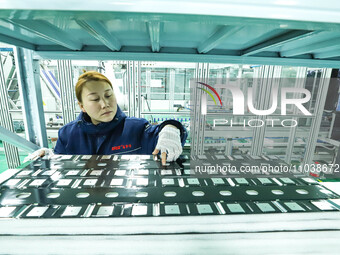 A staff member is checking accessories on an automated production line for energy storage equipment manufacturing modules in Zhangye, China,...
