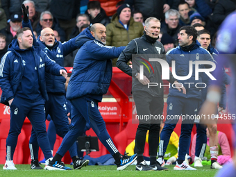 Nuno Espirito Santo, the head coach of Nottingham Forest, is speaking with the fourth official, Graham Scott, during the Premier League matc...