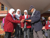 The school principal is distributing candies among students on the first day in Srinagar, India, on March 4, 2024. Schools across Kashmir ar...
