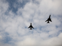 SU22 fly as servicemen exercise ability to cross armored vehicles through Vistula river on ferries during NATO's  Dragon-24 exercise, a part...