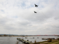 SU22 fly over as servicemen exercise ability to cross armored vehicles through Vistula river on ferries during NATO's  Dragon-24 exercise, a...