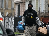 An ATF agent is carrying a bag of evidence at the crime scene. ATF agents are on the scene at a residence on Goodwin Avenue in Newark, New J...