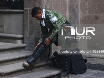 In Mexico City, Mexico, on March 6, 2024, a military police officer is putting on riot gear at the main door of the National Palace to confr...
