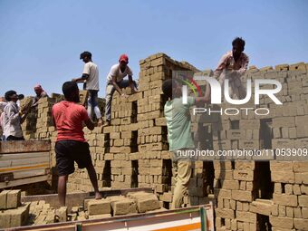 Labourers are working at a brick factory on the outskirts of Guwahati, India, on March 7, 2024. (