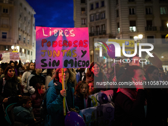 A protester is holding a banner that reads ''Free, powerful, together and without fear'' during the International Women's Day demonstration...