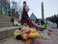 EDMONTON, CANADA - MARCH 9, 2024:
A protester, depicting a Ukrainian woman holding a young child surrounded by children's toys and blood, sy...