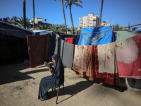 A Palestinian woman is reading the Koran near a camp for displaced people on the second day of the Muslim holy fasting month of Ramadan in D...