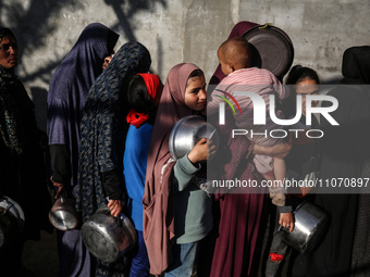 Displaced Palestinians are gathering to receive food donated by a charity before an iftar meal, the breaking of the fast, on the second day...