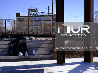 A person is shading themselves from the sun while sitting on a bench swing at the Rail Park trail on the reclaimed Reading Viaduct in Center...