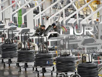 Workers are checking equipment operation at a digital intelligent production workshop at a hardware manufacturing company in Handan, North C...