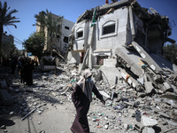 Palestinians are inspecting the damage at a home in Deir al-Balah in the central Gaza Strip on March 13, 2024, which has been hit during an...