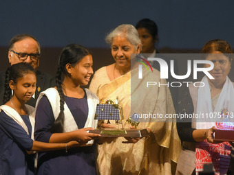 India's Finance Minister Nirmala Sitharaman is presenting a model of ISRO's Chandrayaan 3 lunar mission to a student during the 'Viksit Bhar...