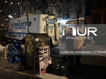 Investigators are examining evidence bags at the crime scene in Manhattan, New York, on March 15, 2024. They are on the scene on Friday morn...