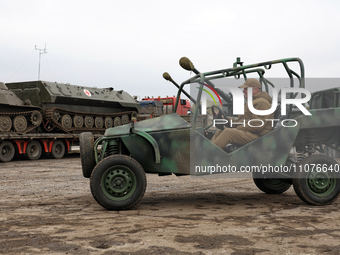 A serviceman is driving a Predator Buggy in Odesa, Ukraine, on March 14, 2024, during an event that provides mobile baths and restored troph...