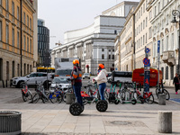Tourist ride scooters in the landmark Krakowskie Przedmiescia Street in Warsaw, Poland on March 15, 2024. (